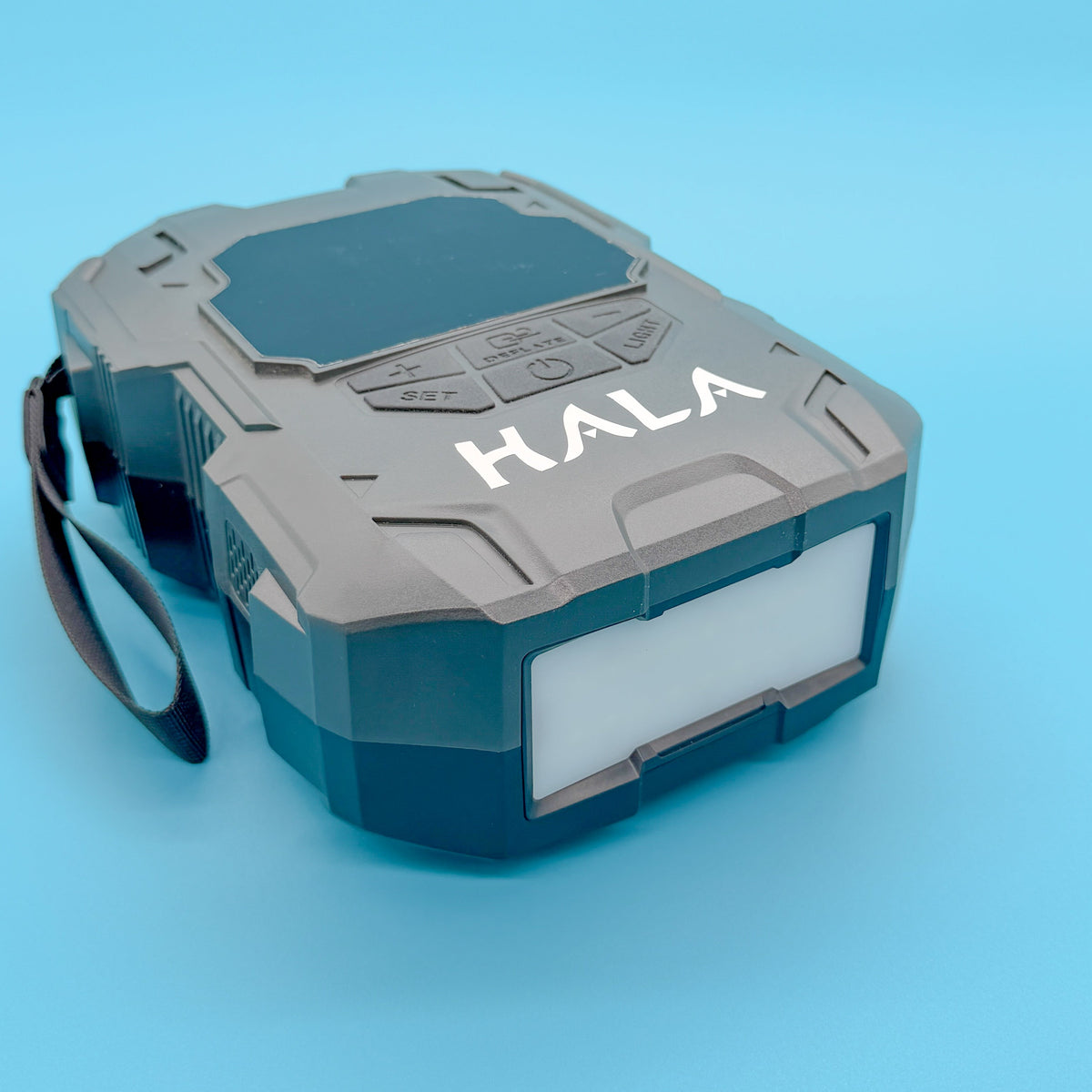 Hala cordless electric SUP pump lying on its side against a teal background, showing the Hala logo on the top face and the moulded carry handle.